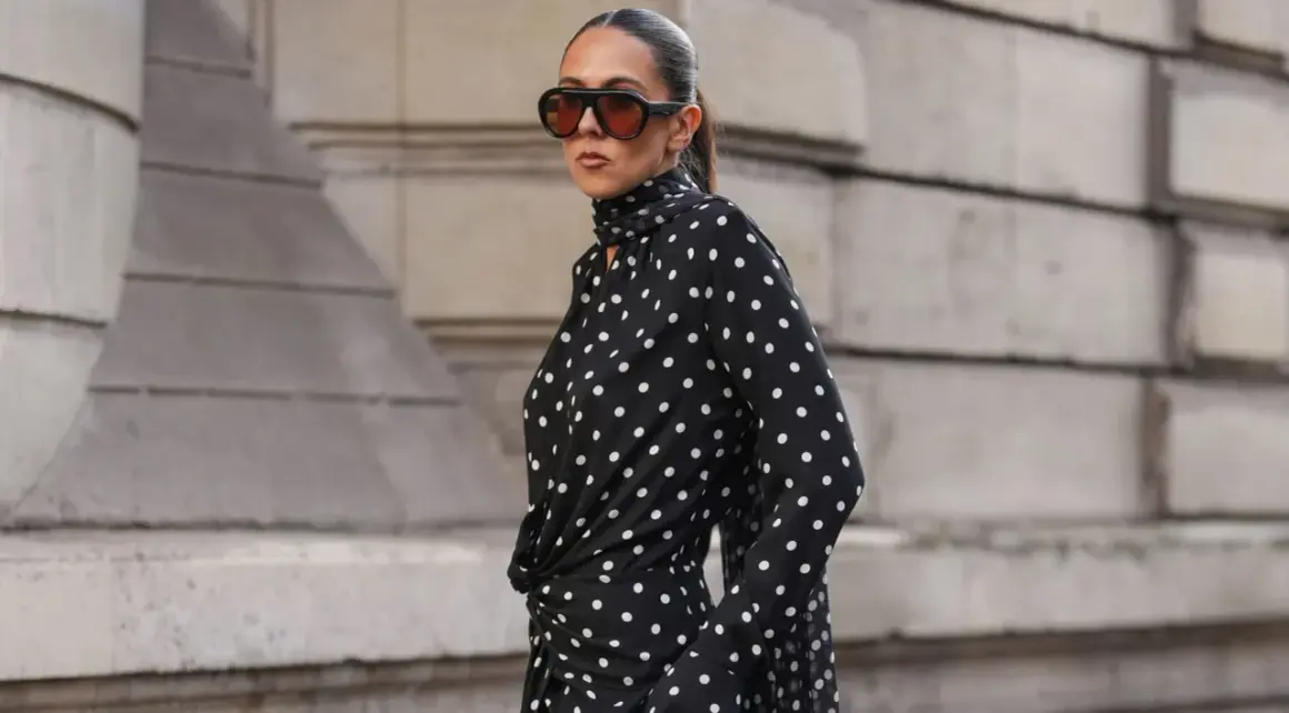 Donna con vestito a pois nero e bianco, occhiali da sole oversize. Come abbinare scarpe a questo look?