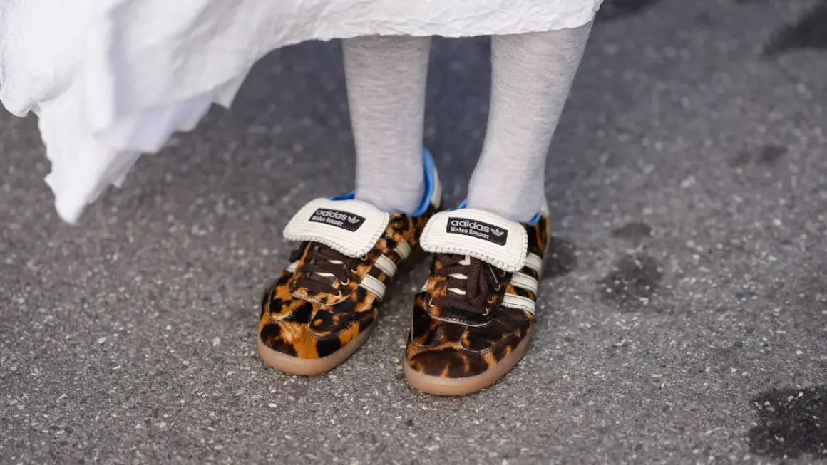 Scarpe leopardate Adidas x Wales Bonner, un outfit audace con calzini grigi e un abito bianco svolazzante.
