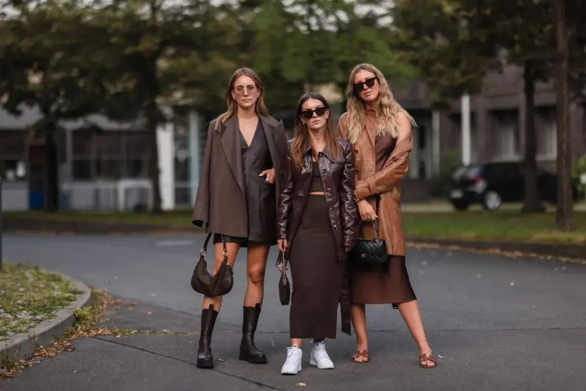Tre donne con outfit in tonalità marroni e cammello. Un esempio di come abbinare il color cammello con capi in pelle e tessuti fluidi.