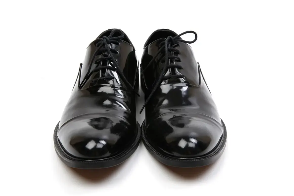 Scarpe smoking nere, lucide e impeccabili, pronte per un'occasione speciale.