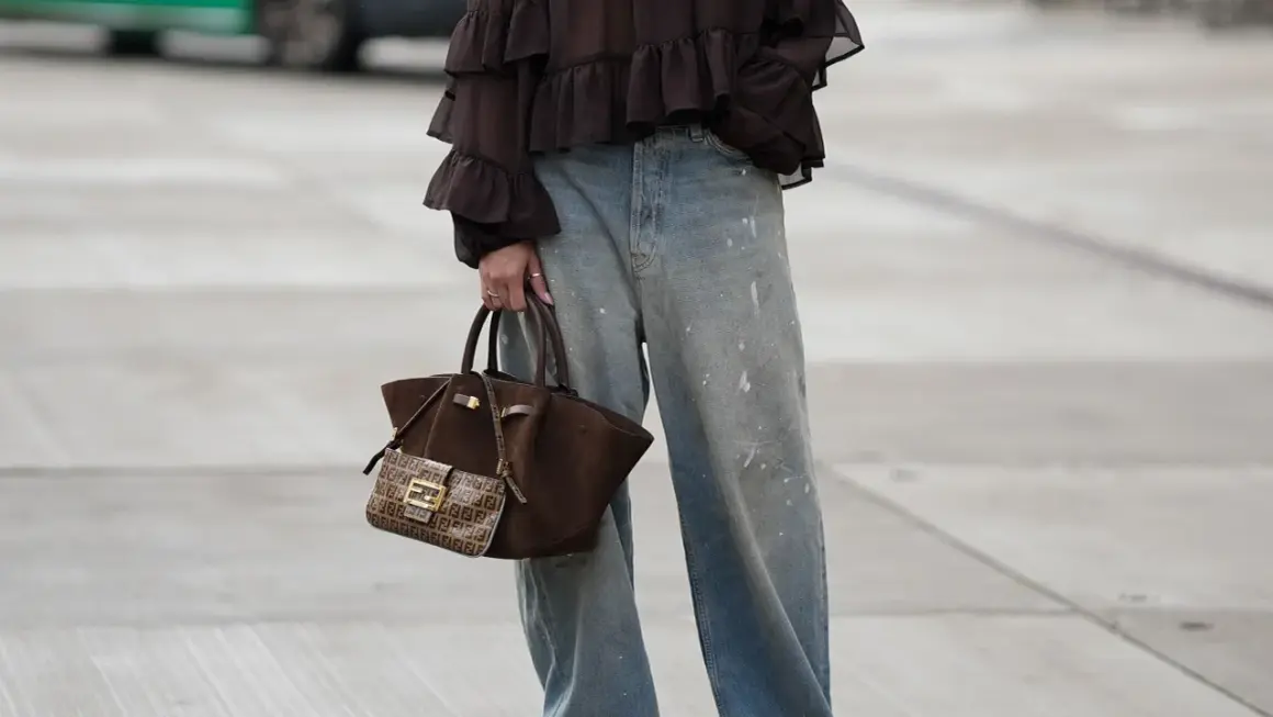 Jeans baggy a chi stanno bene: look casual con blusa a balze e borsa Fendi.