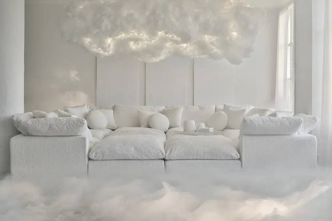Un divano bianco soffice, circondato da nebbia, sotto una nuvola luminosa. Un'atmosfera eterea che anticipa il colore Pantone 2026.