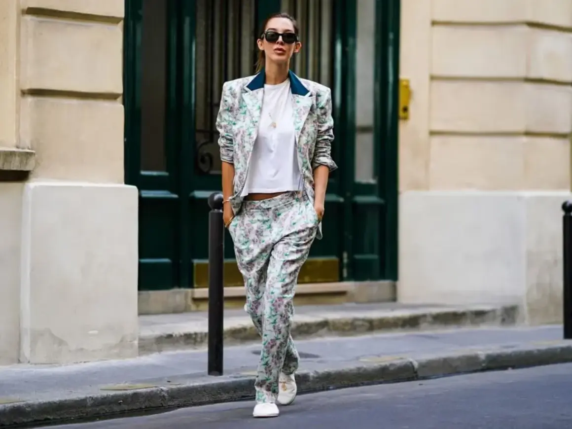 Un outfit da colloquio di lavoro senza tacchi: tailleur floreale con blazer e pantaloni ampi, t-shirt bianca e sneakers.