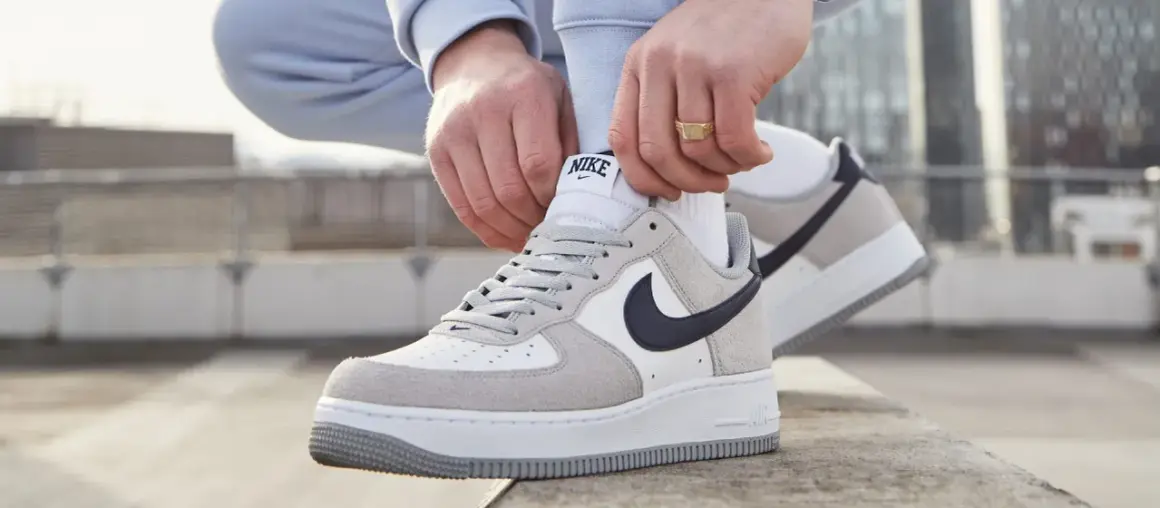 Mani che allacciano le Nike Air Force 1, un classico intramontabile, ricordando quando sono uscite le Air Force 1.