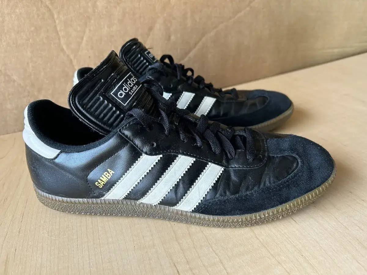 Scarpe Adidas Samba nere con strisce bianche, un classico intramontabile che racconta la sua storia.