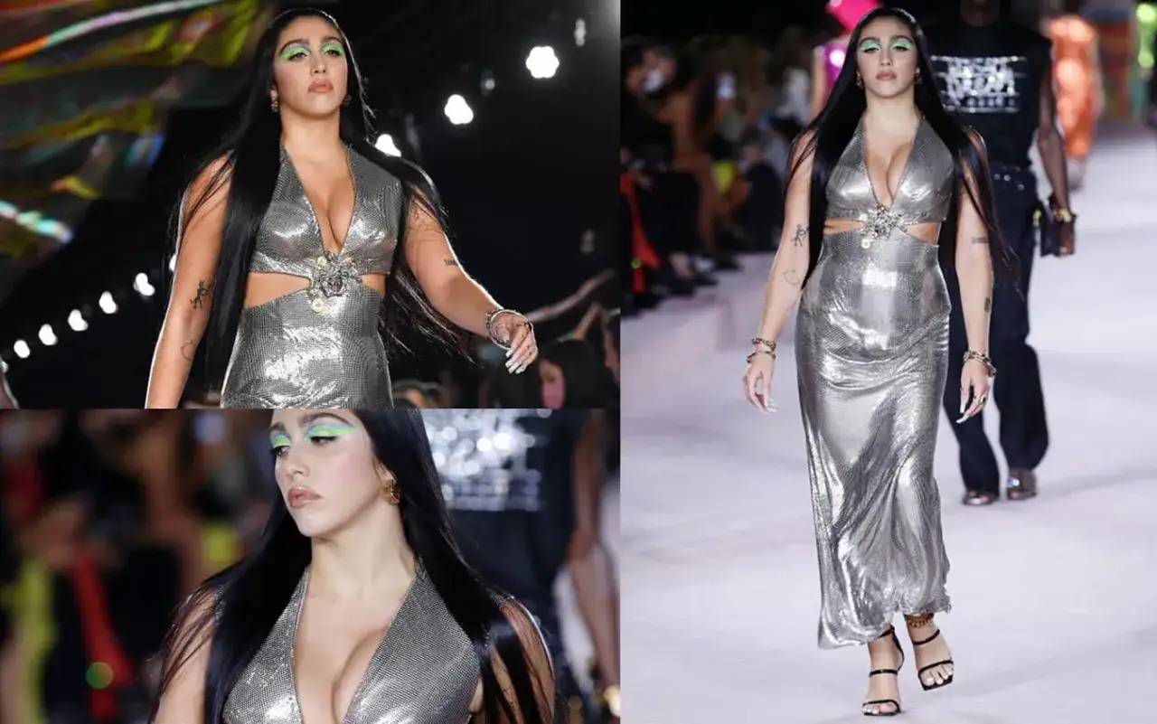 Lourdes Leon sfila in passerella con un abito argentato scintillante, trucco audace e capelli lunghi e scuri.