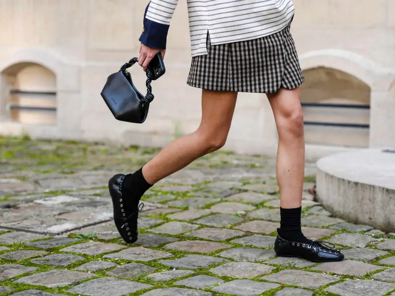 Scarpe stringate nere, perfette da mettere con gonna corta a quadri, completano un look casual chic.