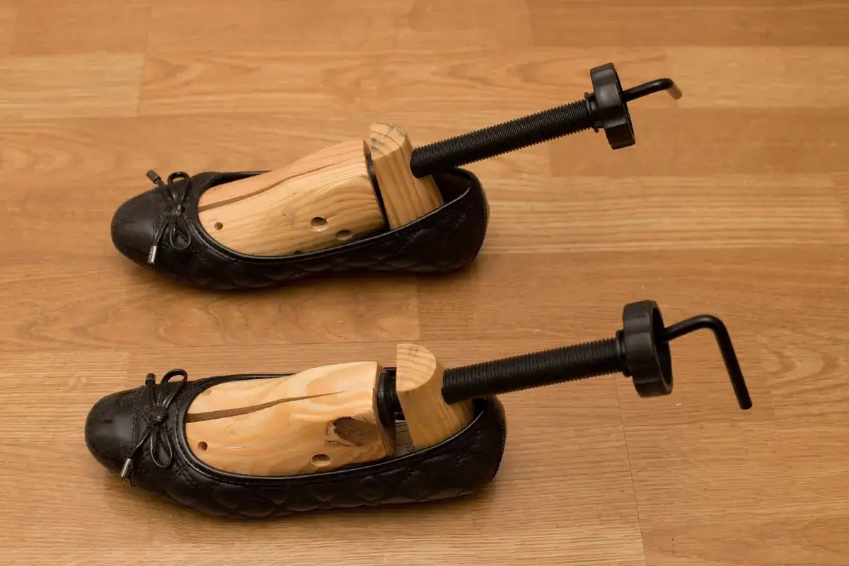Due scarpe nere con tendiscarpe in legno per allargare le scarpe strette in punta.