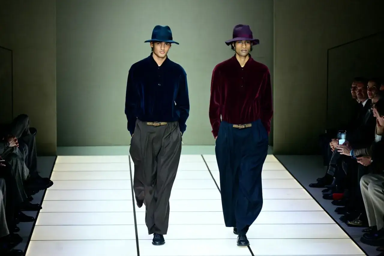 Sfilata di moda uomo: due modelli con cappelli e abiti eleganti, un esempio di stile delle marche abbigliamento uomo famose.