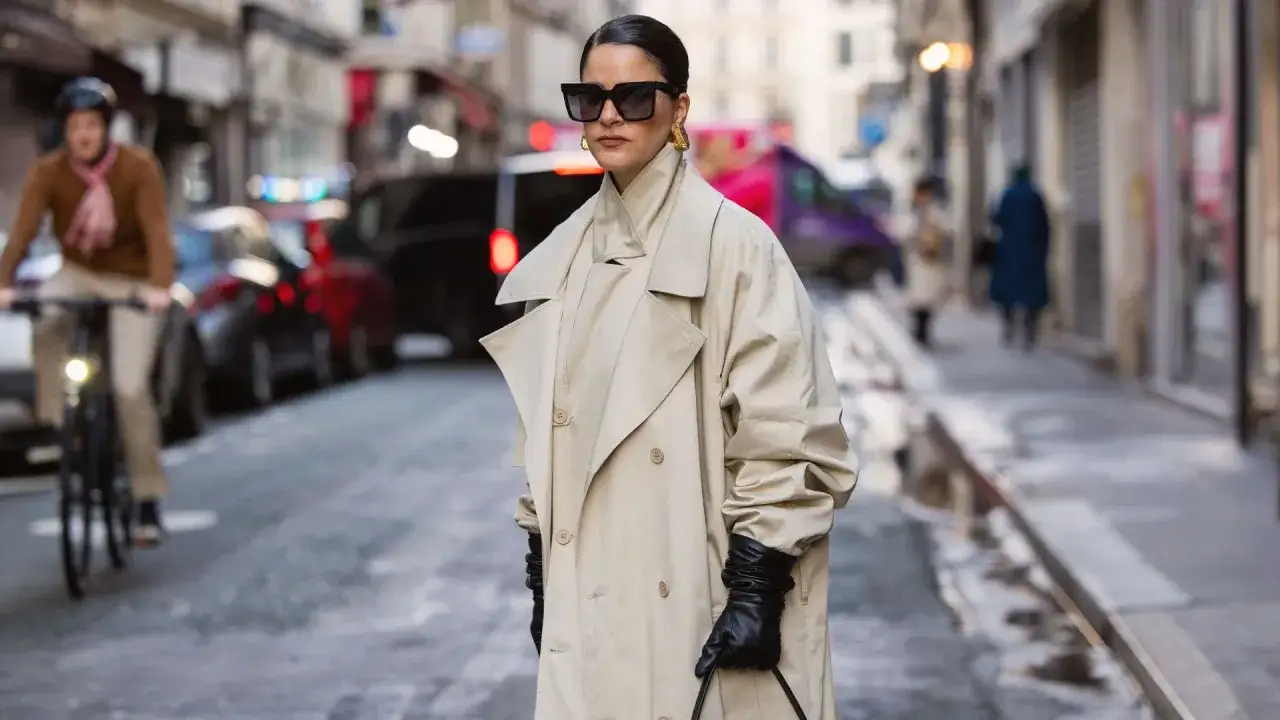 Donna con occhiali da sole e trench beige, guanti neri. Perfetto per quando posso mettere il trench di sera, anche in citt&agrave;.