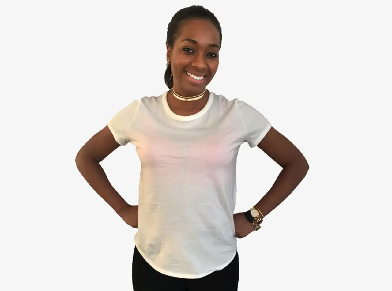 Donna sorridente con camicia bianca trasparente, ideale per capire cosa mettere sotto camicia bianca. Indossa un choker dorato e un orologio.