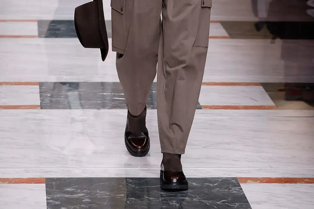 Stivaletti uomo abbinamenti: un look moderno con pantaloni cargo marroni e cappello coordinato.