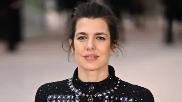 Charlotte Casiraghi, con un'acconciatura raccolta e un abito scuro scintillante, sorride con un'espressione serena.