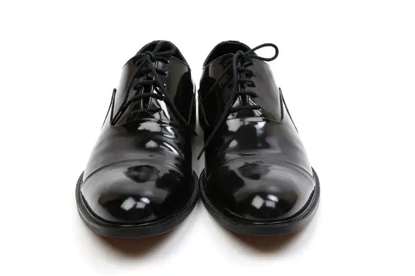 Scarpe smoking nere, lucide e impeccabili, pronte per un'occasione speciale.