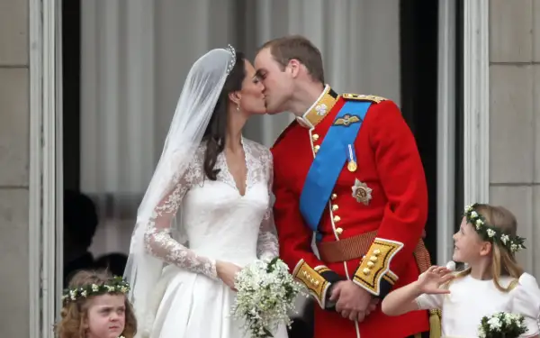 Il matrimonio William e Kate: la sposa bacia il principe William sul balcone, circondati da damigelle.