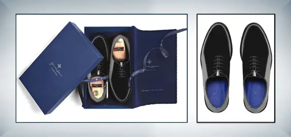 Eleganti scarpe smoking nere lucide, presentate in una scatola blu con accessori e calzascarpe in legno.