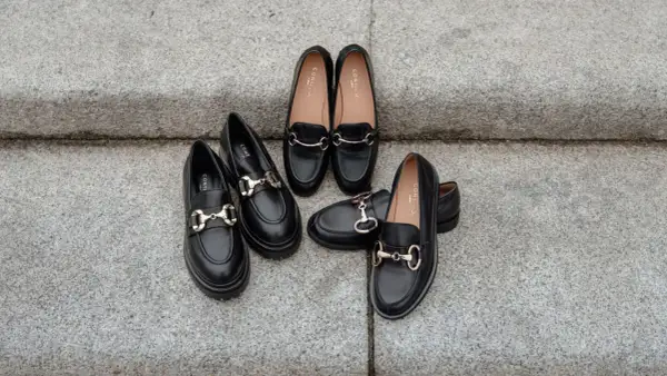 Scarpe nere eleganti con morsetto dorato, perfette come scarpe per vestito corto.